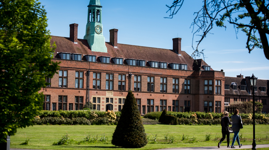 Image of HCA Building on Hope Park Campus, taken during daylight hours with two students walking along the pathway in the bottom right hand corner